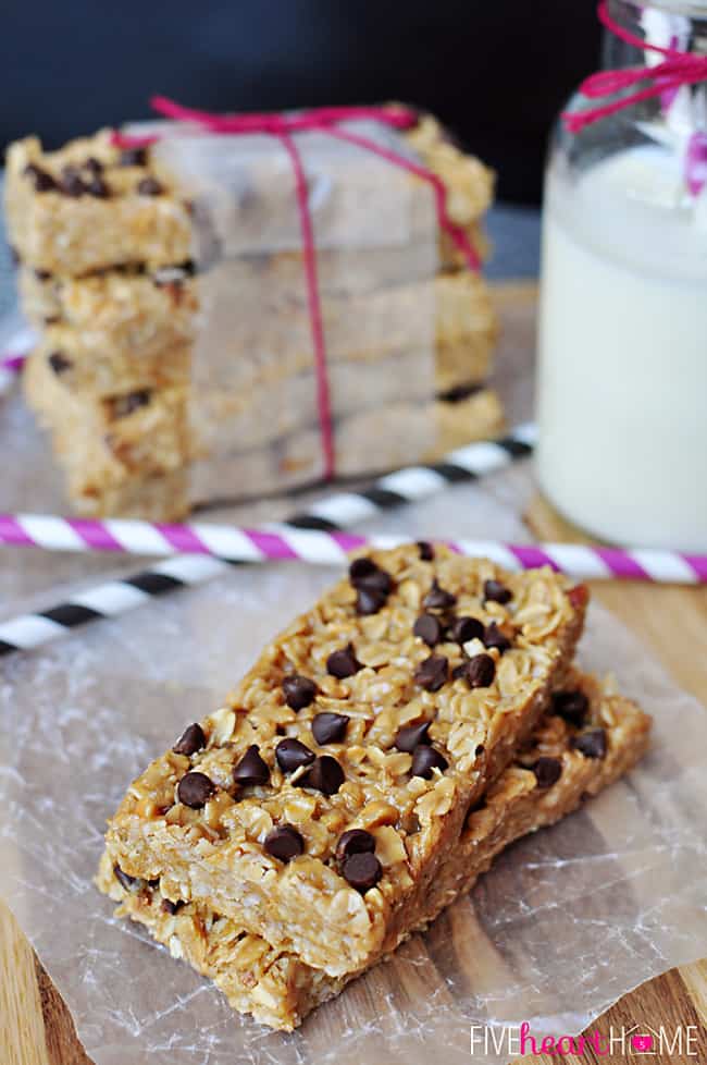 Chewy Granola Bars on wax paper with a glass of milk and paper straws.