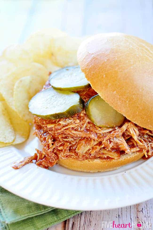 Slow Cooker Chicken Sloppy Joes with pickles on a plate with potato chips.