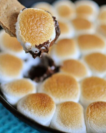 S'mores Dip ~ melted chocolate and toasty marshmallows bake up in a skillet; scoop up with graham crackers for a perfect party dessert! | FiveHeartHome.com
