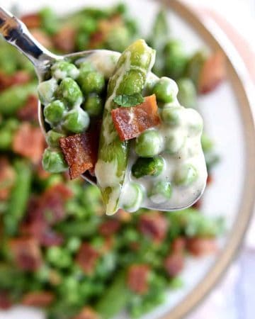 Creamy Spring Peas with Bacon + Mint ~ this ultimate Easter side dish features a delicious combo of flavors and textures from sweet green peas, fresh sugar snaps, salty bacon, a decadent cream sauce, and refreshing pops of mint | FiveHeartHome.com