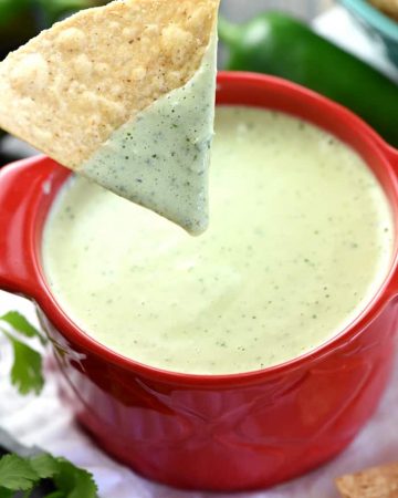 Chip dipped into Chuy's Creamy Jalapeño Dip.