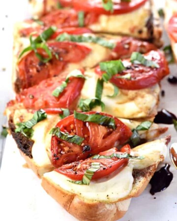 Caprese French Bread Pizza ~ this bursting-with-flavor recipe is brushed with garlic-infused olive oil, layered with fresh mozzarella and thinly-sliced tomatoes, and baked until bubbly before getting finished off with ribbons of basil and a balsamic reduction! | FiveHeartHome.com