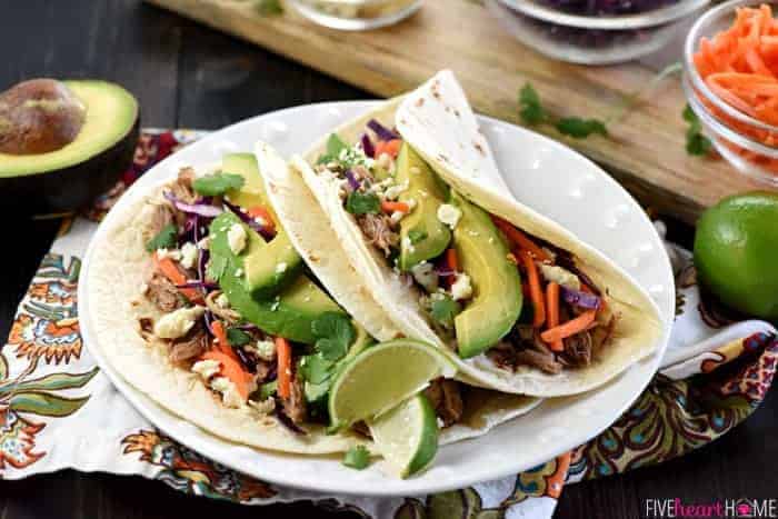 Slow Cooker Honey Lime Pulled Pork Tacos ~ tender, spicy-sweet pork piled on flour tortillas and topped with red cabbage, carrots, avocado, cotija cheese, and fresh cilantro for an easy, effortless dinner...and the leftover pork is fantastic on nachos! | FiveHeartHome.com