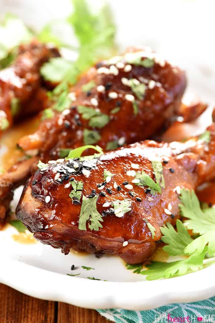 Closeup of a glazed crock pot chicken leg on a platter with more in the background