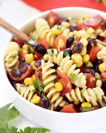 Mexican Pasta Salad in white bowl with spoon.
