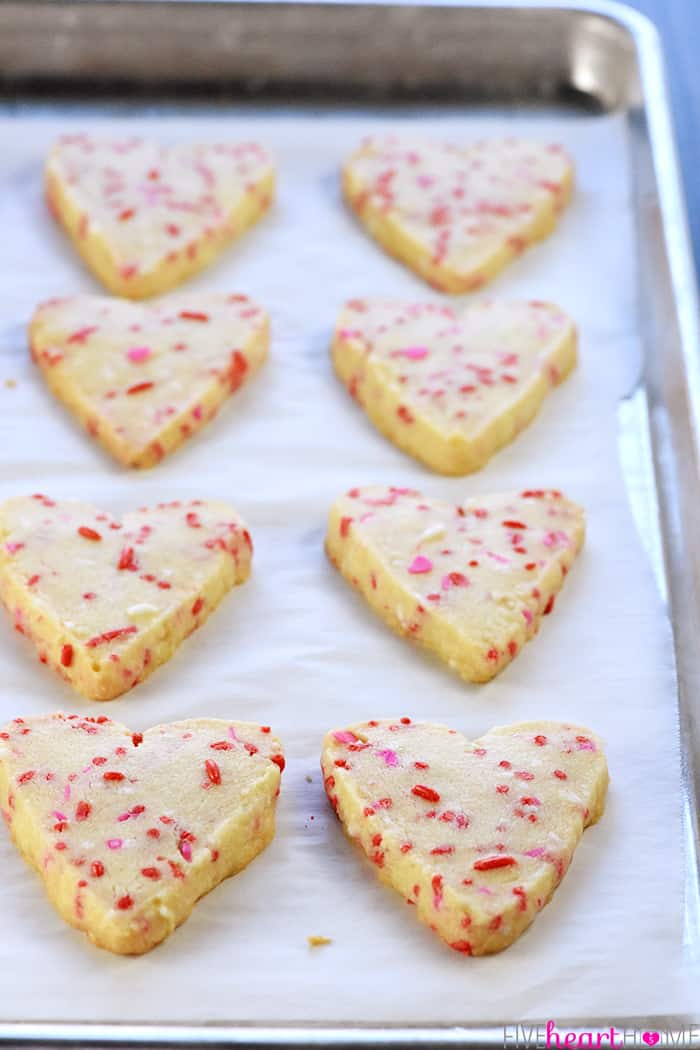 Baking sheet of heart cookies fresh out of the oven.