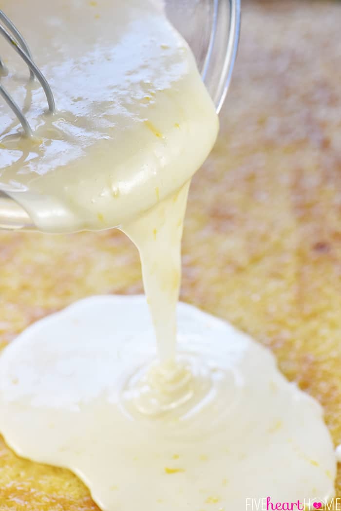 Lemon glaze being poured over lemon cake.
