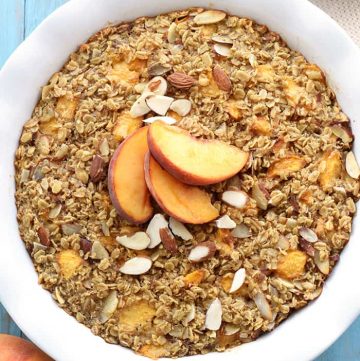 Aerial view of Peach Baked Oatmeal in baking dish garnished with peaches.