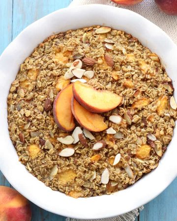 Aerial view of Peach Baked Oatmeal in baking dish garnished with peaches.