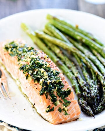 Oven Baked Salmon with Garlic and Parsley on plate with asparagus.