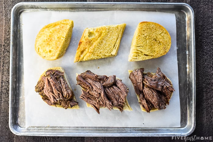 Aerial view of sandwiches being assembled on baking sheet.