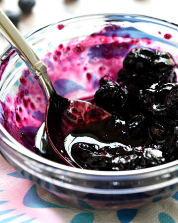 Blueberry Compote in glass bowl with spoon.