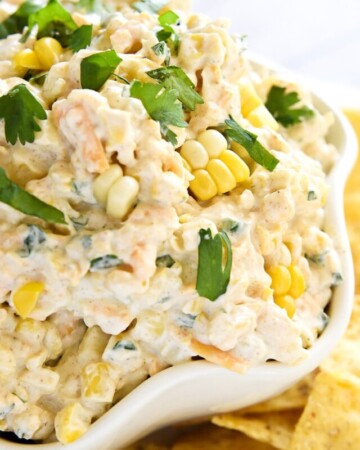 Close-up of Corn Dip in a bowl with fresh corn and cilantro on top.