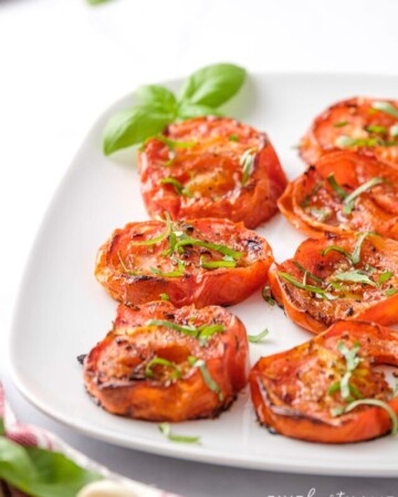 Roasted tomatoes topped with herbs.
