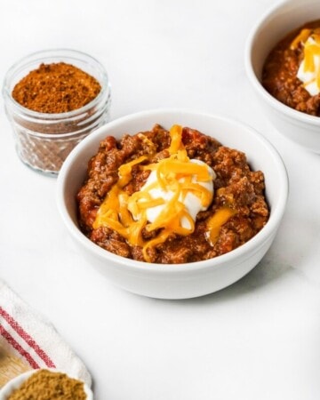 Chili Seasoning and bowls of chili on counter.