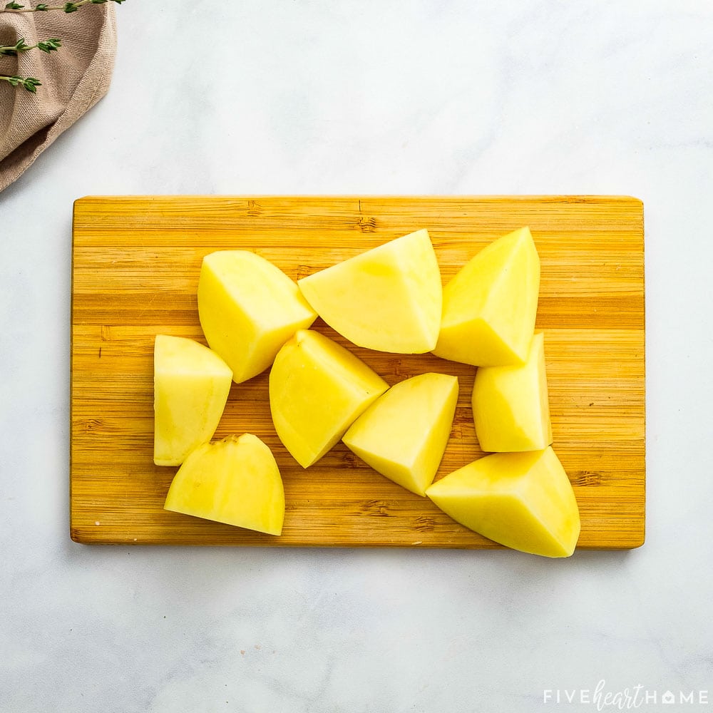 Yukon Golds cut into cubes on cutting board.