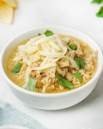 Crockpot White Bean Chicken Chili garnished in bowl.