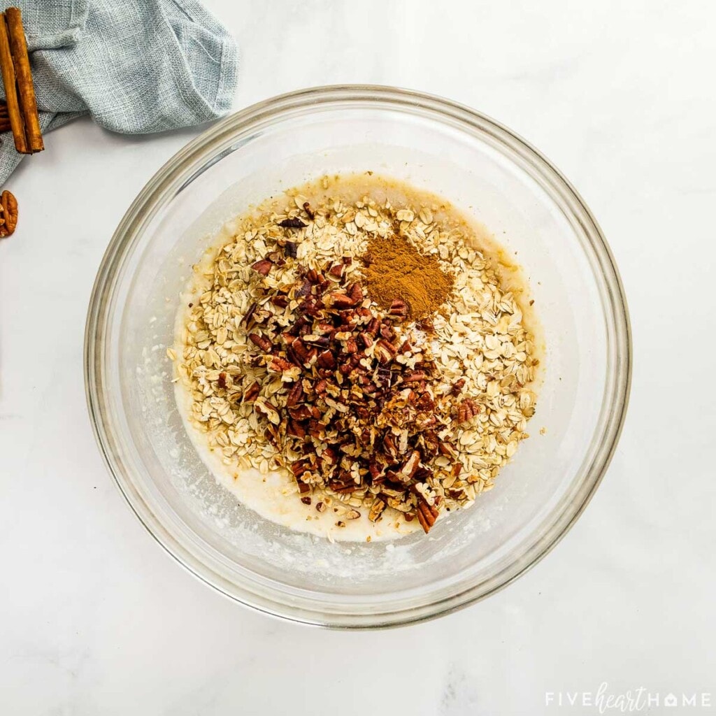 Adding oats, nuts, cinnamon, and salt to Banana Baked Oatmeal recipe.