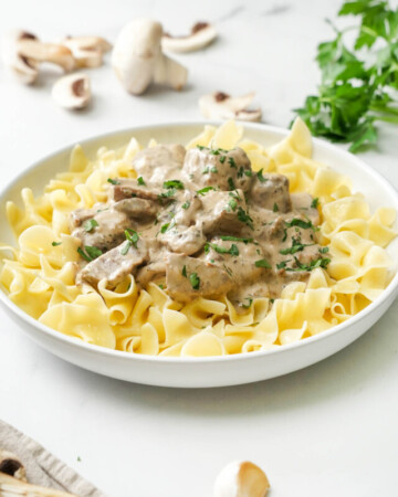 Bowl of Crock Pot Beef Stroganoff over noodles.