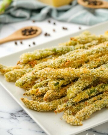 Baked and breaded Asparagus Fries on white platter.