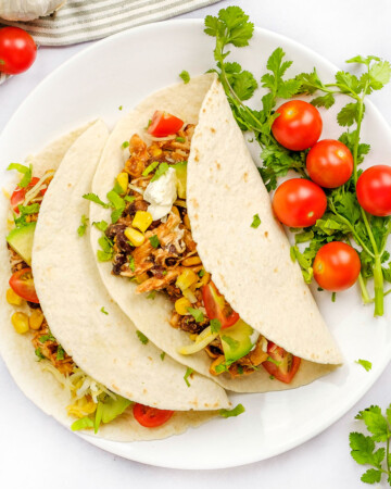 Aeriel view of Crockpot Shredded Chicken Tacos on white plate.