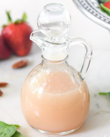Blush Wine Vinaigrette with spinach and strawberries in background.