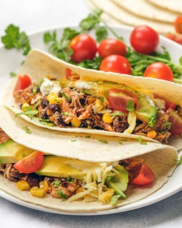 Crockpot chicken tacos with toppings.