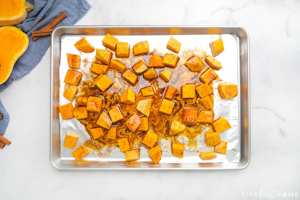 Glazed cubes of butternut squash on baking sheet for roasted squash.