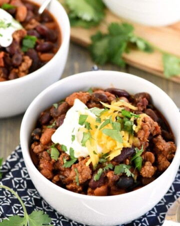 3 Bean Chili with Beef in bowls with spoons.