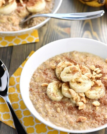 Two bowls of banana oatmeal with spoons.