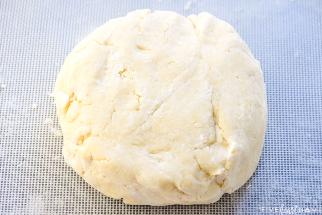 Patting pie crust recipe butter into a disk.