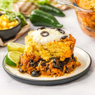 Mexican Cornbread Casserole on plate with limes.