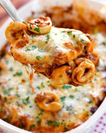 Baked Tortellini being scooped out of dish.