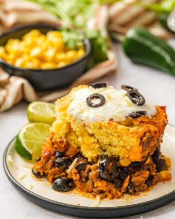Mexican Cornbread Casserole on plate with lime wedges.