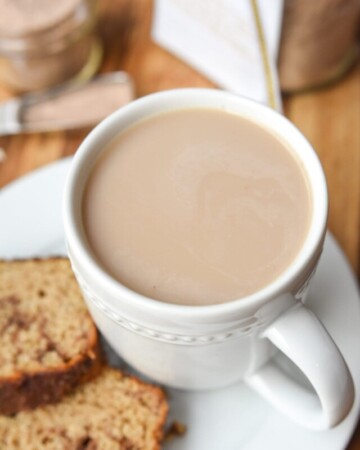 Chai tea latte in mug with cinnamon bread.